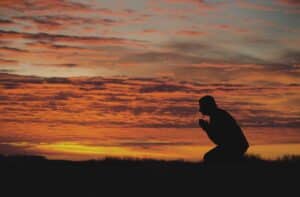 Person kneeling in prayer